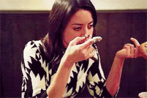 a woman is sitting at a table eating a piece of cake