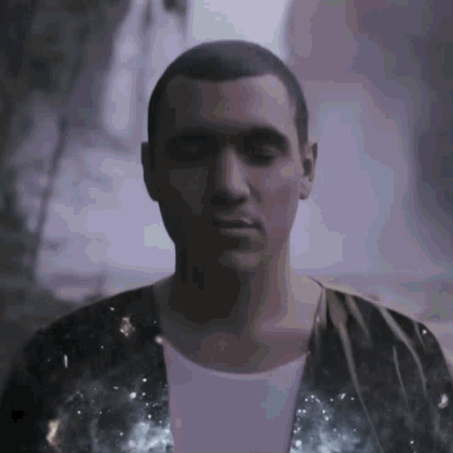a man with his eyes closed is wearing a jacket with a galaxy pattern