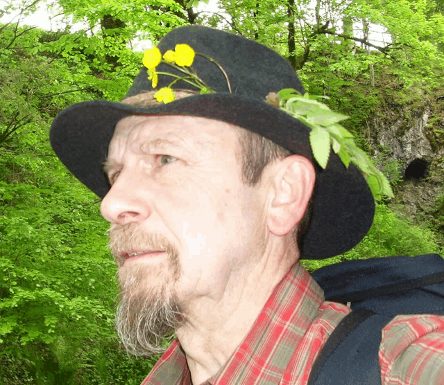 a man with a beard wearing a black hat with flowers on it