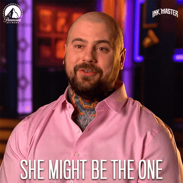 a man in a pink shirt with the words she might be the one above him