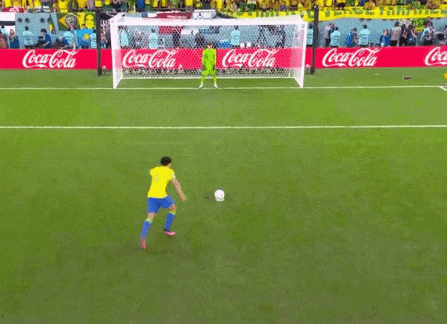 a soccer field with coca cola advertisements on the side