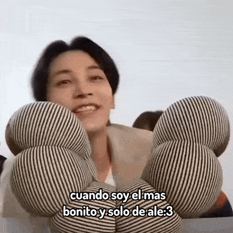 a man is holding a bunch of striped pillows in his hands and smiling .