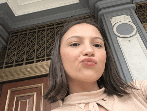 a woman making a funny face in front of a door