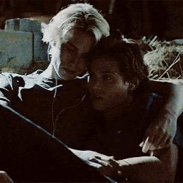 a man and a woman are sitting next to each other and hugging .