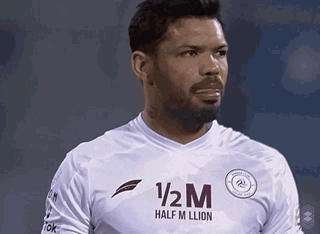 a man wearing a half million shirt looks to the side