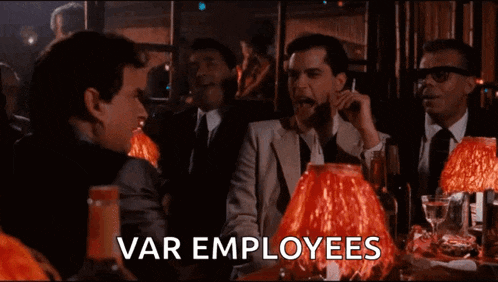 a group of men are sitting at a table with red lamps and the word var employees written on the screen
