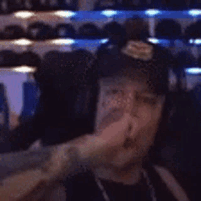 a man wearing headphones and a hat is eating a banana .