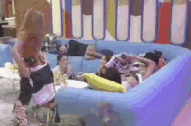 a group of people are sitting on a blue couch in a room .