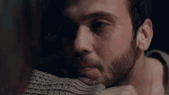 a close up of a man 's face with his hand on his chin