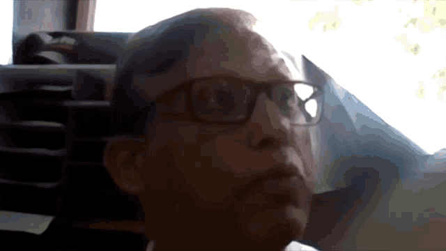 a close up of a person wearing glasses with a blurred background