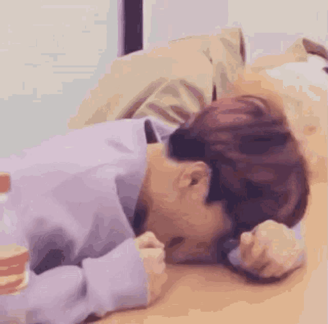 a person is laying on a wooden floor with their head on the floor .