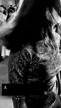 a woman in a sequined dress is standing in front of a crowd of people .