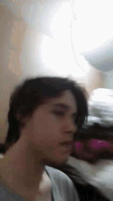 a blurry picture of a person 's face with a pink item in the background