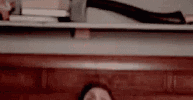 a woman is sitting on a couch in front of a bookshelf .