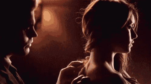 a man and a woman are standing next to each other in a dark room .