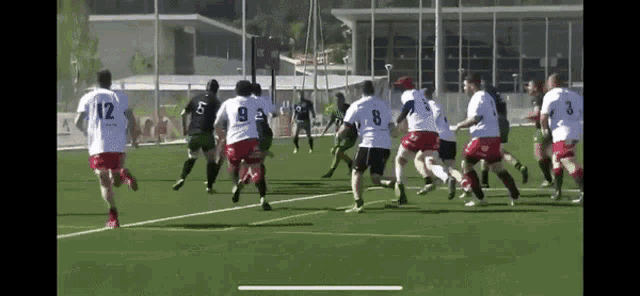 a group of men are playing a game of rugby and one of the players has the number 12 on his jersey