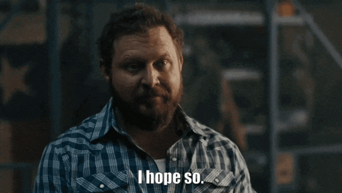 a man with a beard wearing a plaid shirt says i hope so