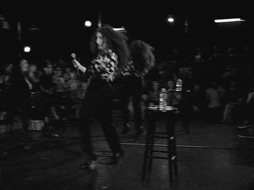 a woman in a floral shirt is standing on a stage