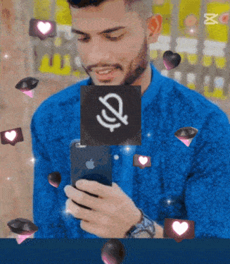 a man in a blue shirt is looking at his phone with hearts around him