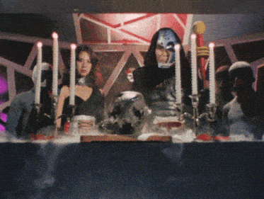 a man and a woman are sitting at a table with candles in front of them