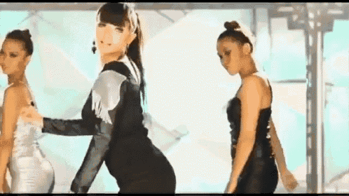 a group of women are dancing on a stage in a video .