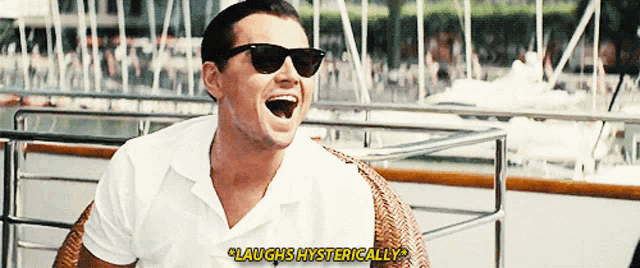 a man wearing sunglasses laughs hysterically while sitting on a boat