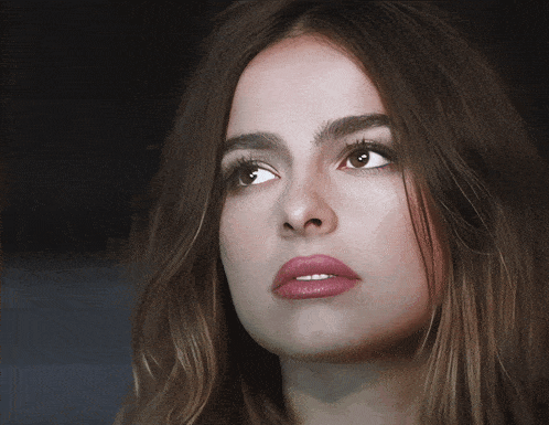 a close up of a woman 's face with long brown hair
