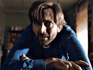 a man with a beard is wearing a blue shirt and a white collar