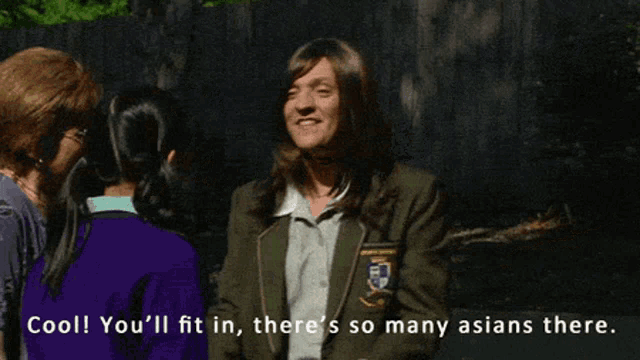 a man in a school uniform talks to two women and says cool you 'll fit in there 's so many asians there .