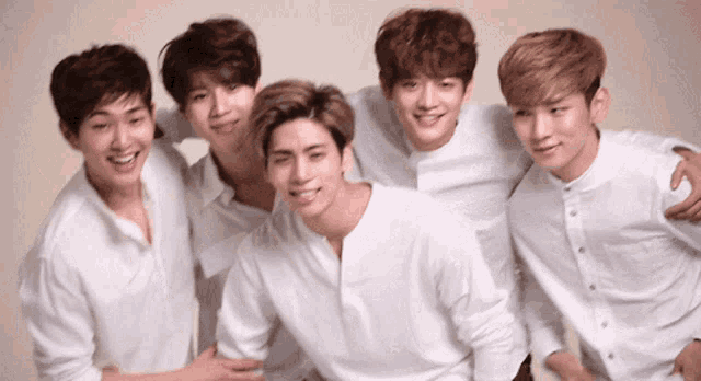 a group of young men in white shirts are posing for a picture together