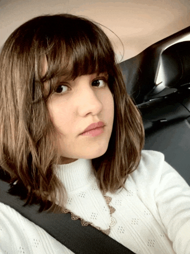 a girl wearing a white sweater and a black belt