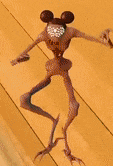 a cartoon character with wings and a mickey mouse head is standing on a wooden surface .