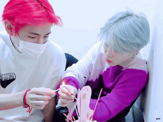 a person with red hair is holding a lighter next to a person with white hair