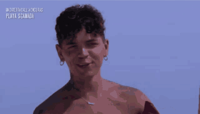 a shirtless man is crying while holding a cell phone in front of a skateboard .