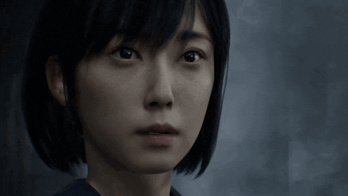 a woman with short black hair looks at the camera
