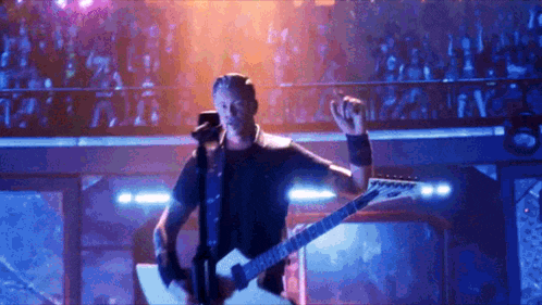 a man is playing a guitar and singing into a microphone .