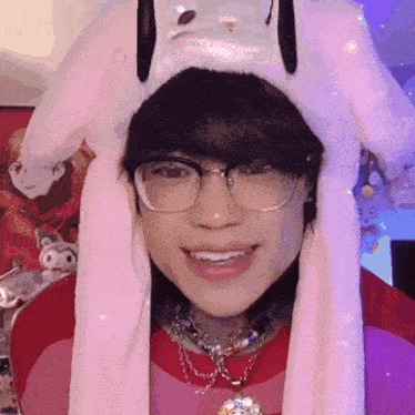 a girl wearing glasses and a bunny hat is smiling for the camera