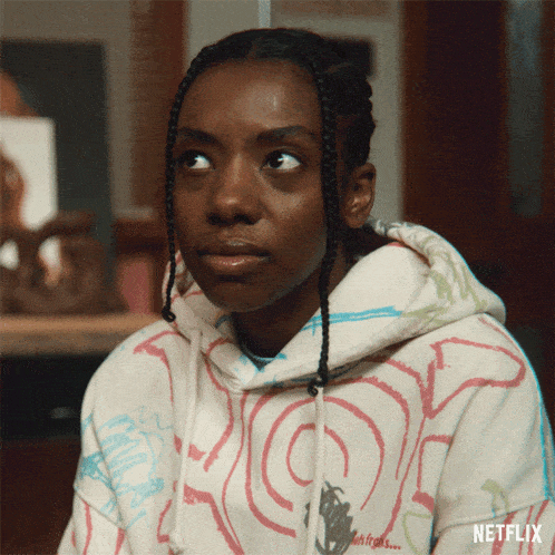 a woman wearing a netflix hoodie looks up at something