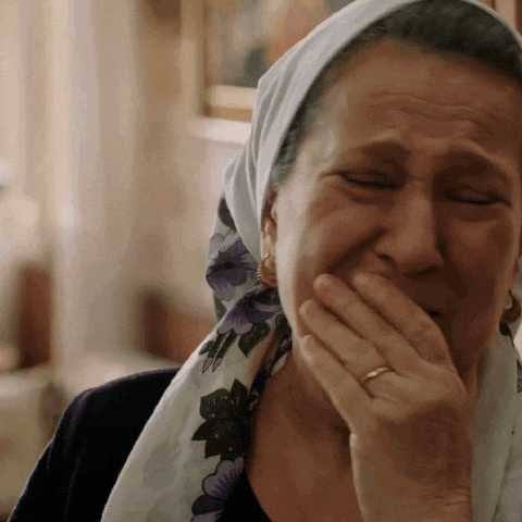 a woman wearing a head scarf is covering her mouth