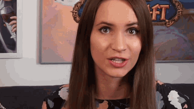 a woman is sitting on a couch in front of a wall with a painting that says ft