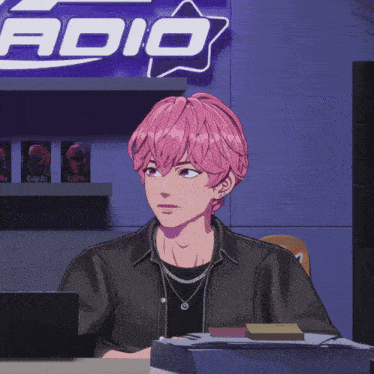 a man with pink hair is sitting in front of a sign that says radio
