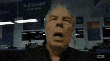 a man is yawning in front of a sign that says " full service "