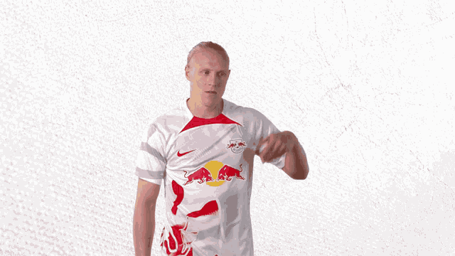 a man wearing a red bull shirt is giving a thumbs up