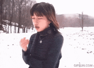 a woman standing in the snow with a gif run.com watermark on the bottom