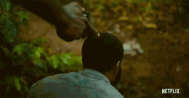 a man with a beard is sweating and looking down in a netflix trailer .