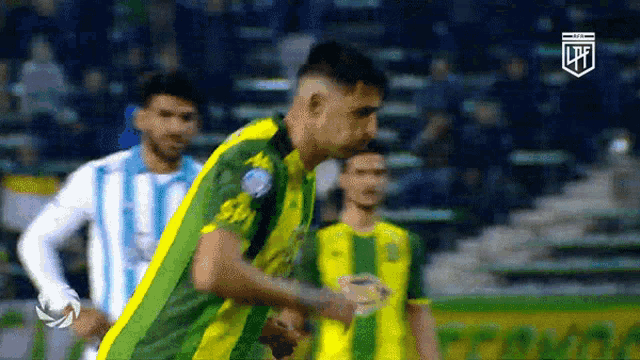 a soccer player wearing a green and yellow jersey with the letter p on the front