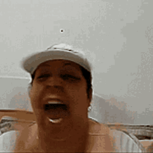 a woman wearing a baseball cap is making a funny face with her mouth open .