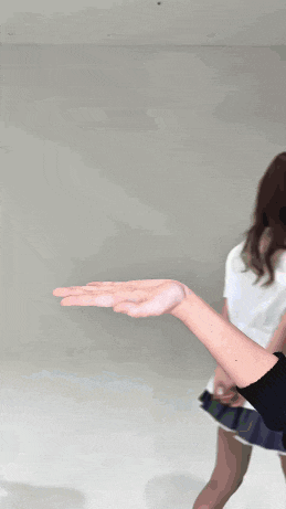 a woman wearing a white shirt with a red heart on it holds out her hand