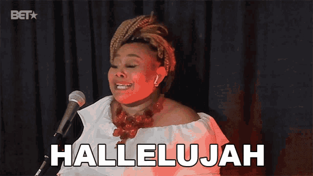 a woman singing in front of a microphone with the word hallelujah written on it