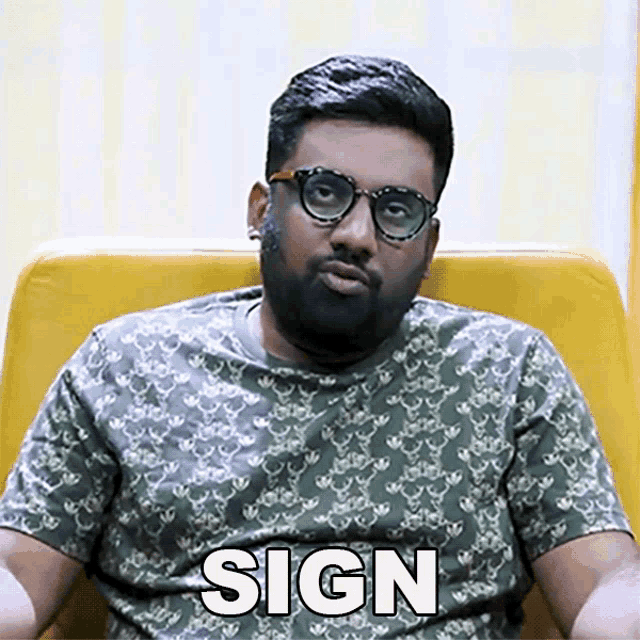 a man wearing glasses and a t-shirt with the word sign on it